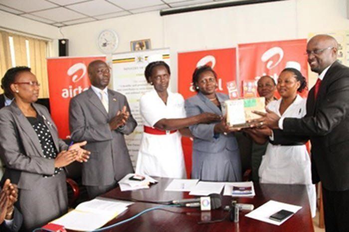 Airtel Legal & Regulatory Director, Mr. Dennis Kakonge hands over 150 phones to the Hon Minister of Primary Health Care, Hon Sarah Opendi as ministry officials look on.