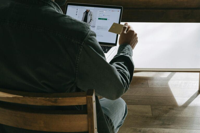 person holding a card while using laptop online security Residential Proxies